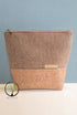 Two-toned pouch with herringbone pattern and cork base on a light gray background